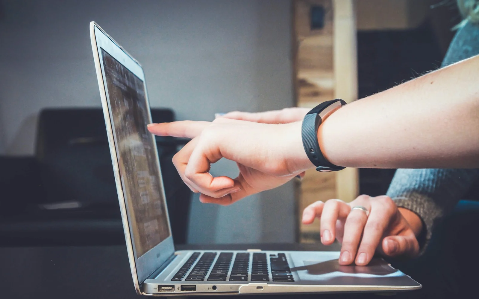 Two coworkers reviewing business information on a laptop