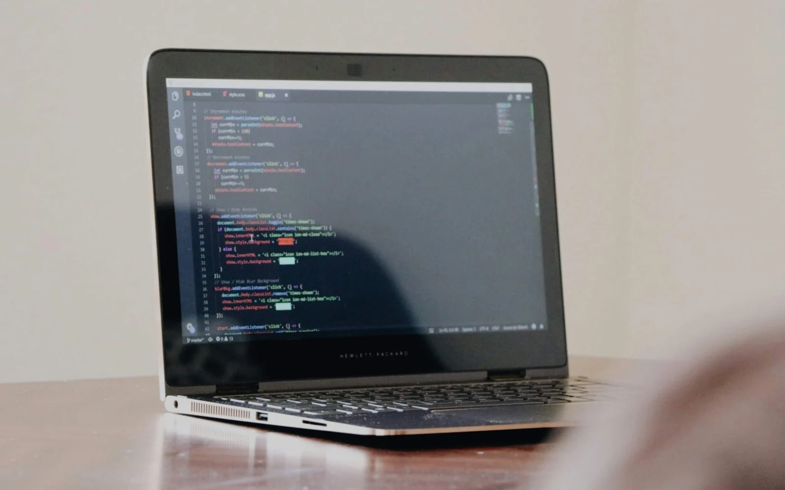 Laptop displaying a code editor on a plain desk
